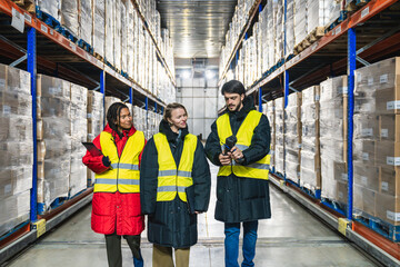 Diverse team of logistics workers managing inventory and stock on shelves in a low temperature cold storage warehouse