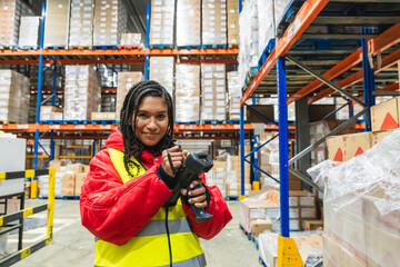 Worker in protective clothing holding a barcode scanner, managing logistics and supply chain in a low temperature warehouse