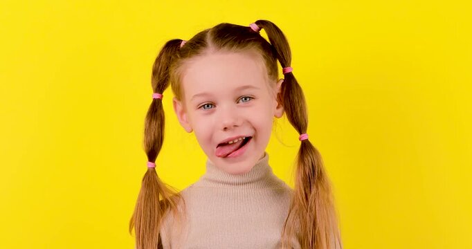 4K footage of a Caucasian girl performing tongue exercises in different directions on a yellow background, illustrating speech therapy, articulation, and learning practice.