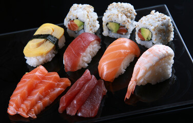 Assortiment de sushi japonais avec saumon, thon, crevette et makis sur plateau noir © PPP