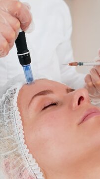 Injection-free mesotherapy or electroporation. Beautician doctor makes client middle-aged woman face therapy in beauty clinic salon. Adult girl skin care anti-age spa procedure. Aesthetic cosmetology