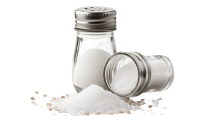 Two glass salt shakers are featured prominently with one standing upright full of white granulated salt and another lying on its side spilling some coarse grains onto the surface below.
