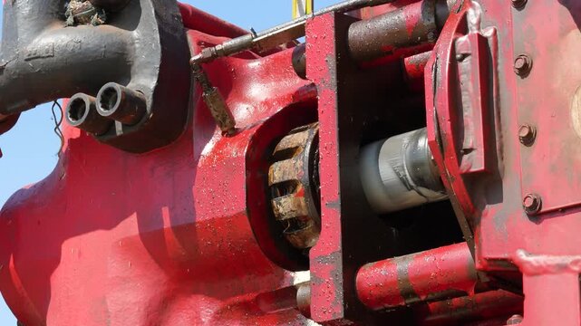 Triplex water pumping machine during the piston moving to discharge fluid with high pressure. Industrial machine working footage, close-up with selective focus.