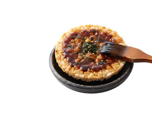 Japanese rice cracker with soy sauce in a bowl, set against a white background.

