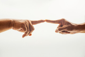 Two human hands reaching to touch fingertips on white background, representing connection, trust, teamwork, empathy, communication, and meaningful interaction in personal or professional contexts.