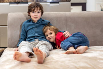 Two brothers relaxing on sofa at home
