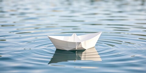 A small, pristine white paper boat floats on calm water,  nautical,  craft project