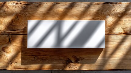 White rectangular box on textured wooden surface with shadow