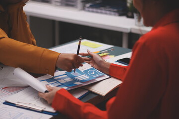 Team of uxui designers pointing at computer screen, discussing new mobile app design in the office