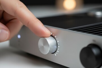 A hand gently turns the volume knob of a modern audio amplifier, creating a warm sound experience. Soft lighting enhances the relaxed atmosphere in the room