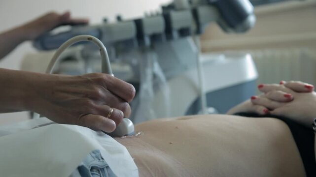 Gynecologist performing ultrasound exam of a female patient, extreme close-up