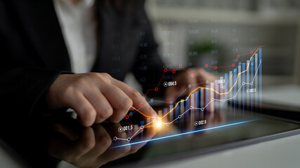 Business professional uses a tablet to analyze financial growth trends with interactive graphics, highlighting the importance of data-driven decision-making and investment strategies. Scalp