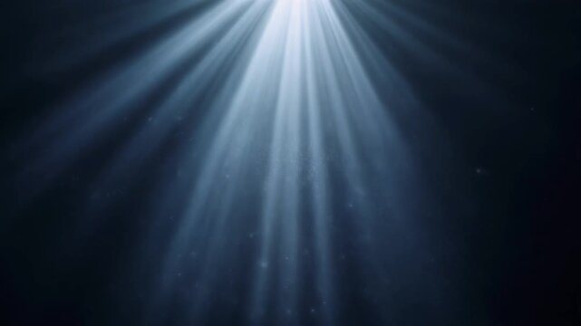 Dramatic cinematic volumetric light beams streaming down through floating dust particles in deep darkness, perfect abstract overlay background animation.