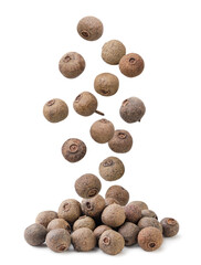 Allspice peas falling on a pile on a white. Isolated