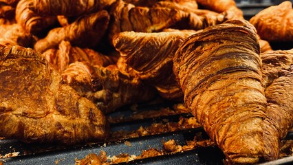 Artisan croissants topped with nut crumble, baked to a deep golden color. Traditional French pastry displayed in a bakery setting.