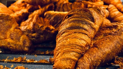 Buttery croissants with crisp exterior and nut garnish, freshly baked and ready to serve, perfect for breakfast or caf&eacute; menu.