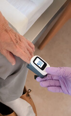 Female patient taking vital signs with pulse oximeter at hospital