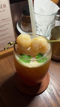 a glass of lychee tea with two lychees on top at Pizzeria Cavalese, an Italian restaurant in BSD area. ice, tea, and lychee fruit, refreshing drink