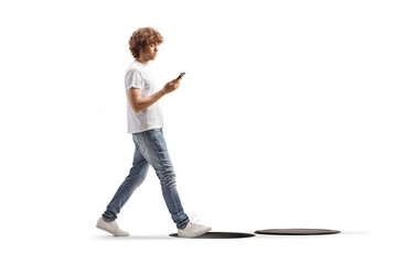 Distracted man with a smartphone walking toward open manhole