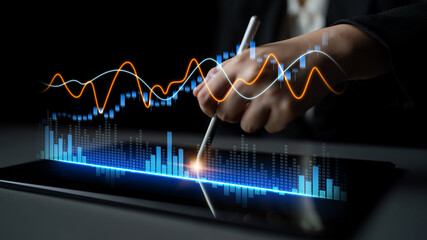 A hand holding a stylus interacts with a tablet screen displaying colorful data graphs, showcasing the fusion of technology and business analytics in modern entrepreneurship. Scalp