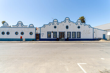 Colorful colonial buildings in Lüderitz, a small coastal town in Namibia, facing the Atlantic Ocean. Historic German architecture contrasts with desert landscapes, harbor views. © coffeinlix 