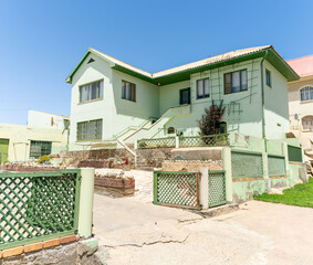 Colorful colonial buildings in Lüderitz, a small coastal town in Namibia, facing the Atlantic Ocean. Historic German architecture contrasts with desert landscapes, harbor views. © coffeinlix 