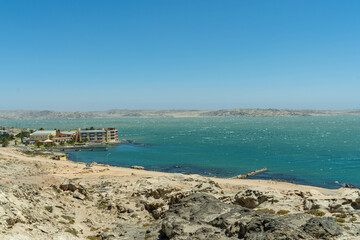 Colorful colonial buildings in Lüderitz, a small coastal town in Namibia, facing the Atlantic Ocean. Historic German architecture contrasts with desert landscapes, harbor views. © coffeinlix 