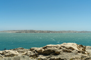 Colorful colonial buildings in Lüderitz, a small coastal town in Namibia, facing the Atlantic Ocean. Historic German architecture contrasts with desert landscapes, harbor views. © coffeinlix 
