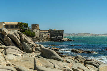 Colorful colonial buildings in Lüderitz, a small coastal town in Namibia, facing the Atlantic Ocean. Historic German architecture contrasts with desert landscapes, harbor views. © coffeinlix 