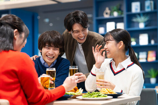 飲食店で飲み会をする若い男女