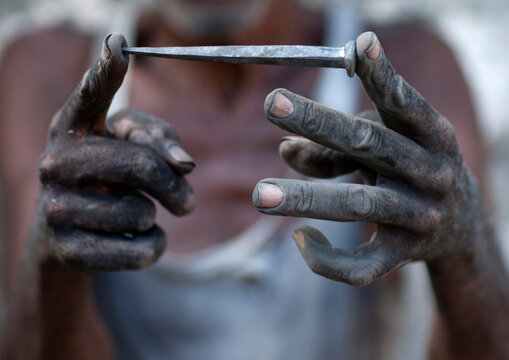 Blacksmith showing a forged nail for the boats, Lamu county, Matondoni, Kenya