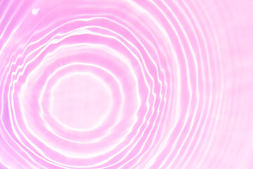 Purple water bubbles on the surface ripples. Defocus blurred transparent pink colored clear calm water surface texture with splash and bubbles. Water waves with shining pattern texture background