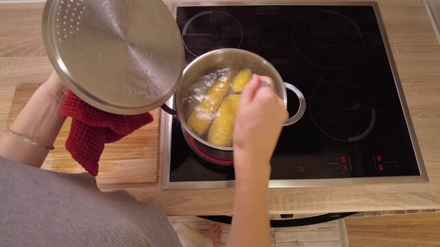 Boiling Fresh Corn on the Stove in a Stylish and Modern Kitchen Space