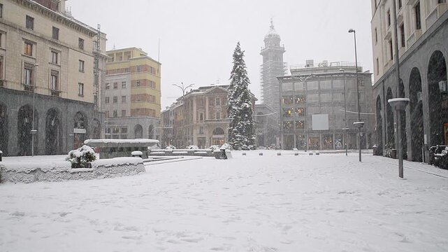 Bad weather in winter in northern Italy. City under heavy snowfall. Snow covered square in the historic center of Varese, square Monte Grappa