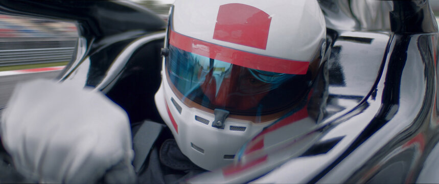 A close-up of a race car driver in motion, captured while speeding on a track
