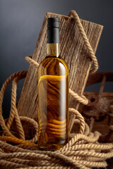 Bottle of  white wine with old weathered board and hemp rope.