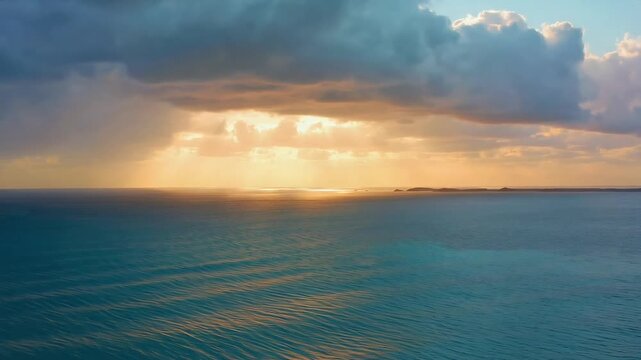 Golden Sunset Light Reflecting on Calm Ocean Under Storm Clouds