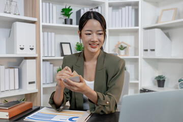 Professional businesswoman reviewing financial reports and taking notes at her workspace, focused on planning, decision making, and data analysis to support strategy and effective management.