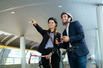 Business colleagues walking with bicycles in modern urban environment