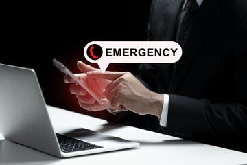 Businessman is depicted using a smartphone, with an alert notification signaling an emergency call. A laptop is seen near his hand. The urgent nature of the emergency call.