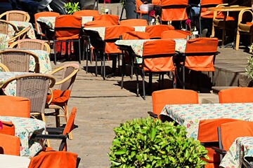 Outdoor restaurant tables on a city street, restaurant interior