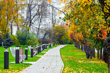 an empty path in an autumn park. empty benches in an autumn park. deserted autumn park
