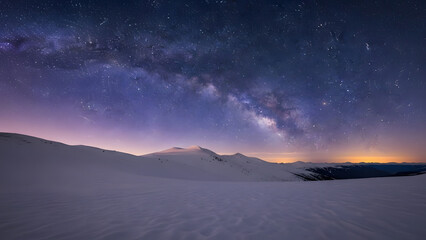 Vast desert landscape bathed in the ethereal glow of the Milky Way galaxy at night.