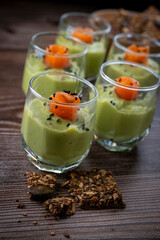 Smoked salmon shot glasses guacamole served with homemade crackers. High quality photo