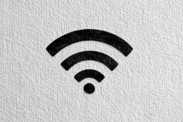 A black Wi-Fi symbol on a textured white background, representing internet connectivity and wireless communication.