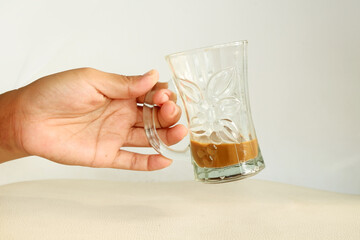 Hand Holding a Glass Mug with Coffee