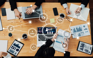 A group of professionals engaged in a collaborative meeting, utilizing technology and data visualization tools to enhance discussions and strategy planning in a modern office setting. Amity