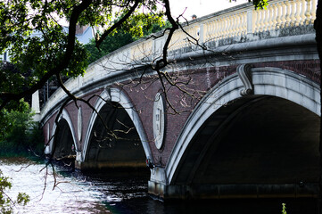 Historic Stone Arch Bridge Over Calm River: Multiple Rounded Arches Spanning Autumn Riverbank Scenery