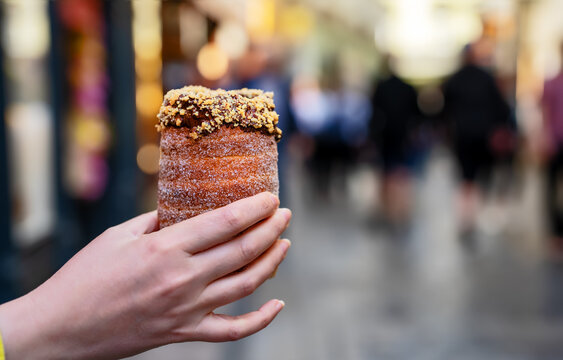 Woman holding traditional Czech chimney cake pastry.
