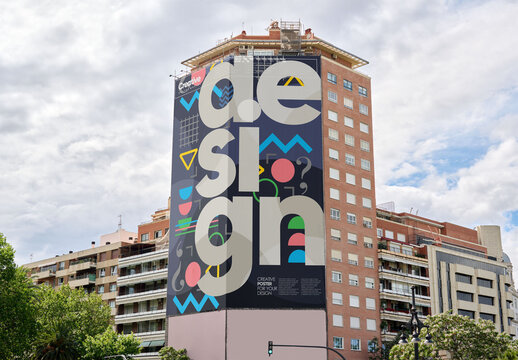 mockup displays a blank billboard located on a tall building in an urban area, ideal for out-of-home advertising. Valencia